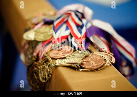 Nahaufnahme Gymnastik Medaillen, Bänder auf schwebebalken. Gold, Silber und Bronze, die von talentierten High School Mädchen. Team Wettbewerb und individuelle Treffen. Stockfoto