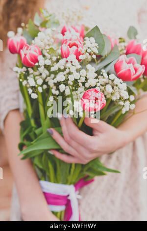 Flower Bouquet von roten Tulpen und Gypsophila in der Frau, Hände, Nahaufnahme Stockfoto