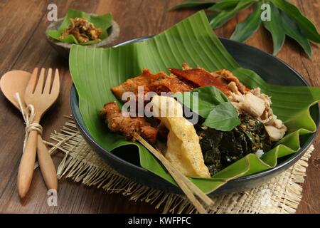 Nasi Campur babi guling. Balinesen Reis Reisgericht mit gedämpftem Reis garniert mit verschiedenen Gerichte der traditionellen Schweinebraten. Stockfoto