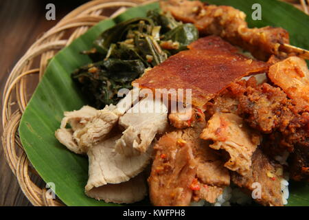 Nasi Campur babi guling. Balinesen Reis Reisgericht mit gedämpftem Reis garniert mit Vielzahl von schweinebraten Gerichte. Stockfoto