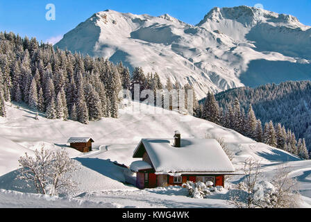 Kleines Holzhaus in einer wunderschönen Winterlandschaft in Arosa, Schweiz Stockfoto