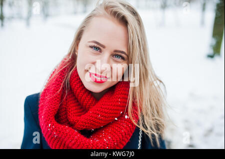 Portrai des blonden Mädchen in roten Schal und Mantel auf Wintertag. Stockfoto