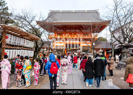 Japan, Kyoto, Yasaka Schrein. Für das neue Jahr. Die Menschen gehen zum Yasaka Schrein für ihre Hatsumode, erster Besuch des neuen Jahres. Gruppe von Frau im Kimono stehen in der Nähe des Großen vermillion Gatter und Rahmen mit großen weißen chochin, Papier Laternen. Stockfoto