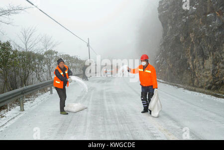 Xiangyang, Hubei Provinz Chinas. 3 Jan, 2018. Arbeitnehmer verteilt Schnee schmelzen Chemikalien auf einem Abschnitt der Bundesstraße 241 im Houping Stadt Baokang Grafschaft, die Zentrale China Provinz Hubei, Jan. 3, 2018. Eine kalte Welle brachte die Schneefälle an mehrere Orte in China. Credit: Chen Quanlin/Xinhua/Alamy leben Nachrichten Stockfoto