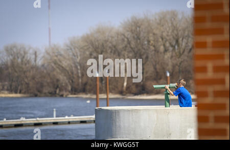 Rock Island, Iowa, USA. 20 Mär, 2017. Braiden Schulte, 9, der Rock Island sieht im Blick auf die Innenstadt von Davenport aus über dem Mississippi Fluss an Shweibert Riverfront Park in Rock Island am Montag, den 20. März 2017. Viererkabel - Bereich Bewohner genossen, sonnigen Wetter am ersten Tag des Frühlings, indem Sie die Möglichkeit, im Freien für eine Spitze zu erhalten. Credit: Andy Abeyta/Viererkabel - Zeiten/ZUMA Draht/Alamy leben Nachrichten Stockfoto