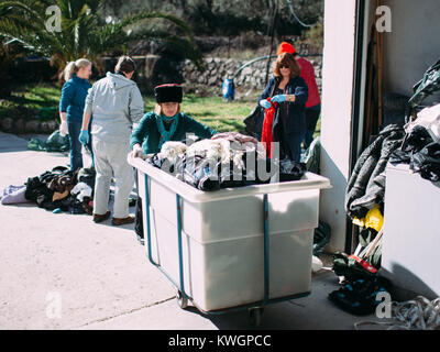 Mytilene, Griechenland. 8. Feb 2016. Katerina eine Irische schmutziges Mädchen zieht die Kleidung Warenkorb auf dem Weg zur Waschmaschine. schmutzige Mädchen von Lesbos ist eine Gruppe von Freiwilligen im September 2015 geboren von der Idee der Alison Terry-Evans. Die Gruppe von Freiwilligen ist fast nur Frauen Gruppe, die sich um das Sortieren, Waschen, und bereit stellen wiederverwendet wird, die Kleidung der Hunderttausende Migranten, die durch die Insel. Die Idee ist, dass anstelle der Kauf neuer Kleidung oder Warten auf Spenden, nasse Kleidung von Migranten, die mit Booten, die ausgetauscht werden mit sauberem, die auf andere migrantische gehörte Stockfoto