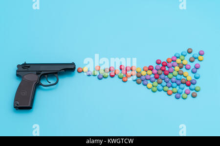 Pistole schießende Süßigkeiten, Applique Kunstwerk, Schuss aus einem Gewehr Aroma bunte Bonbons und Gummibärchen Stockfoto