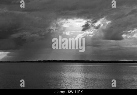 Schwarz & Weiß Sturm auf Bay Licht durch einen Bruch in den Wolken Stockfoto