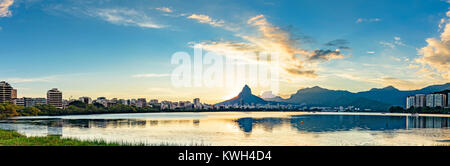 Panoramabild des Sommeruntergangs von der Lagune Rodrigo de Freitas mit den Gebäuden der Stadt Rio de Janeiro aus gesehen, Stockfoto