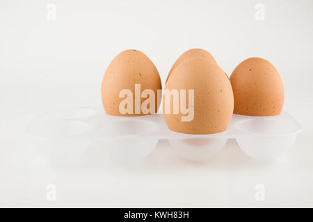 Vier frische Eier im Landhausstil auf weißem Hintergrund Stockfoto