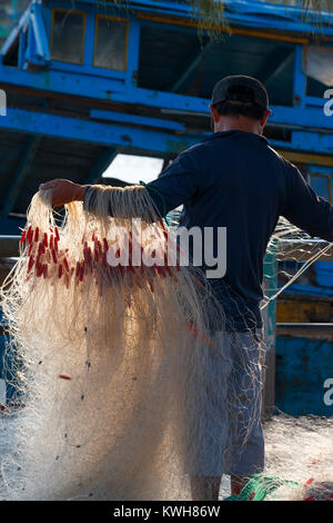 Fischer in ihre Netze in der Hafenstadt Phan Thiet, Vietnam. Stockfoto