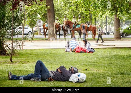 Santiago de Chile, Chile - Oktober 24, 2013: Die Menschen in einem städtischen Park mit der berittenen Polizei in einem Abstand (Carabineros de Chile). Stockfoto