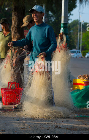 Fischer in ihre Netze in der Hafenstadt Phan Thiet, Vietnam. Stockfoto