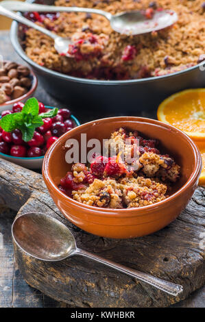 Moosbeere, Apfel und Haselnuss auf Holztisch bröckeln Stockfoto