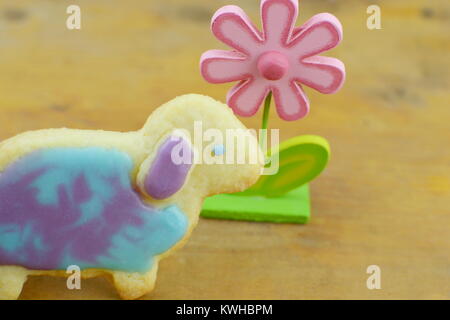 Ostern cookies und eine bunte Blume auf Holz- Hintergrund. Ostern cookies und eine bunte Blume auf Holz- Hintergrund. Stockfoto