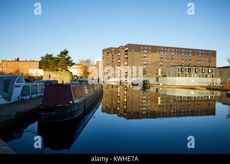 Marina an der Neuen Islington, Ancoats, Manchester, mored narrowboats als Häuser und neue Wohnung Gebäude spiegeln sich in der Stille Wasser Stockfoto