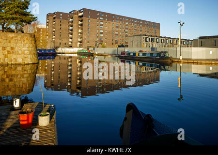 Marina an der Neuen Islington, Ancoats, Manchester, mored narrowboats als Häuser und neue Wohnung Gebäude spiegeln sich in der Stille Wasser Stockfoto