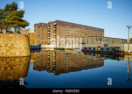 Marina an der Neuen Islington, Ancoats, Manchester, mored narrowboats als Häuser und neue Wohnung Gebäude spiegeln sich in der Stille Wasser Stockfoto