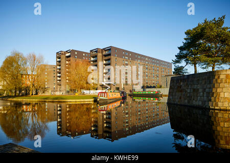 Marina an der Neuen Islington, Ancoats, Manchester, mored narrowboats als Häuser und neue Wohnung Gebäude spiegeln sich in der Stille Wasser Stockfoto