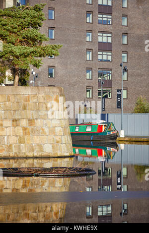 Marina an der Neuen Islington, Ancoats, Manchester, mored narrowboats als Häuser und neue Wohnung Gebäude spiegeln sich in der Stille Wasser Stockfoto