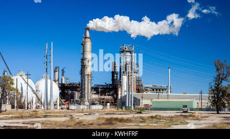 Ölraffinerie Anlage mit Schornstein Durchbrennenrauch gegen einen klaren blauen Himmel Stockfoto