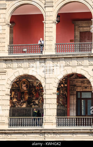 Touristen Anzeigen von Diego Rivera's Wandgemälde an der Mexico Plaza de la Consitucion Stockfoto