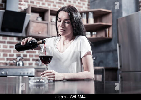 Traurig brünette Frau gießen Wein Stockfoto