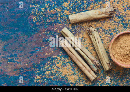 Cinnamomum verum. Zimtstangen und Pulver auf Schiefer Stockfoto