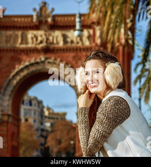 in Barcelona für einen perfekten Winter. glückliche trendige Frau in Ohrenschützer in Barcelona, Spanien mit Karte Stockfoto