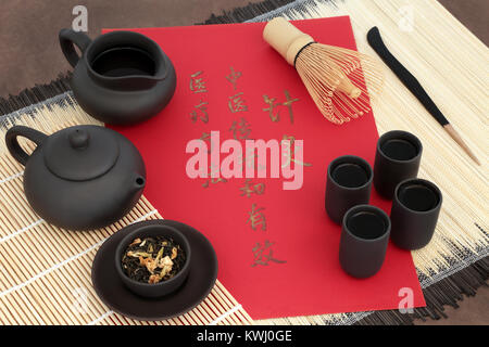 Grün Jasmin Tee in der chinesischen Kräutermedizin mit orientalischen Teekanne, Tassen, Blätter, Schneebesen,, Wasser Kanne auf Bambus mit Kalligraphie script. Stockfoto