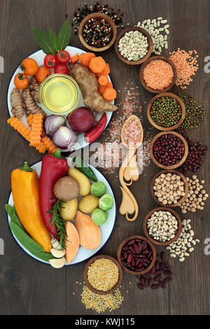 Health Food Konzept mit frischem Gemüse, Hülsenfrüchte, Kräuter, Gewürz, Himalaya Salz und Olivenöl mit Lebensmittel, die einen hohen Gehalt an Vitaminen, Mineralien und Antioxidantien. Stockfoto