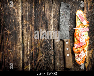 Sandwich mit Tomaten, Krebsfleisch und pikanter Sauce auf einem frischen Brötchen. Auf einer hölzernen Hintergrund. Stockfoto