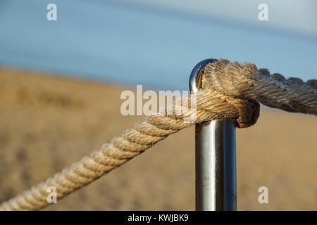 Detail des Seils Geländer Strand Gehweg, alte Metall Pol, Urlaub am Meer, Ruhe, Entspannung, Stockfoto