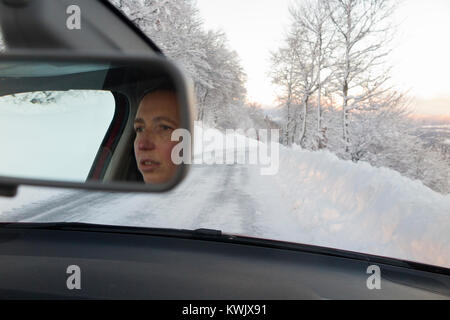 Darlehen einzelne Frau Treiber entlang fahren rutschigen eisigen verschneiten Französischen Alpen Country Road, mit Eis, nach einem Blizzard. Schlechte Bedingungen im Winter. Frankreich Stockfoto