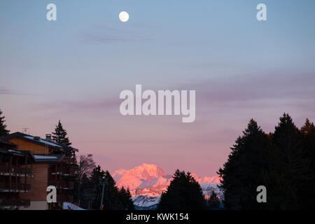 Ansicht der Waxing gibbous Mond (fast Vollmond) steigende bei Sonnenuntergang über den Alpen von Plateau de Sur Lyand gesehen, im Departement Ain in Frankreich. Stockfoto