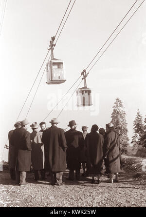 Dieses Bild markiert die Inbetriebnahme der Seilbahn Pohorska vzpenjača im Jahr 1957 auf dem Bergrücken Maribor Pohorje in Slowenien, einem Teil der touristischen Infrastruktur der Region Mitte des 20. Jahrhunderts. Stockfoto