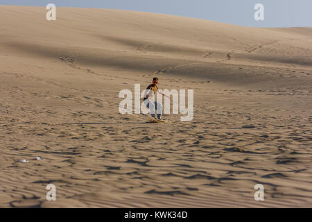 Bild von einem jungen Mann bei Sonnenuntergang, Sandboarding, Ica Huacachina, Peru Stockfoto