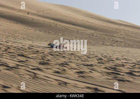 Bild von einem jungen Mann bei Sonnenuntergang, Sandboarding, Ica Huacachina, Peru Stockfoto