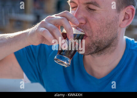 Junge tausendjährigen Mann Probenahme ein Bier Flug in einer gasthausbrauerei im Sommer im Freien Stockfoto