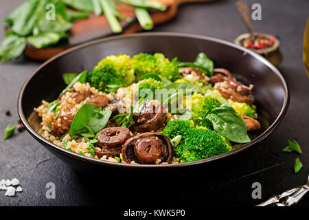 Diätetisches Menü. Gesund vegan Salat Gemüse Brokkoli, Champignons, Spinat und Quinoa in eine Schüssel geben. Stockfoto