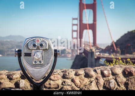 Klassische Ansicht der Münze betrieben Fernglas mit berühmten Golden Gate Bridge im Hintergrund an einem schönen sonnigen Tag mit blauem Himmel und Wolken im Sommer, Stockfoto