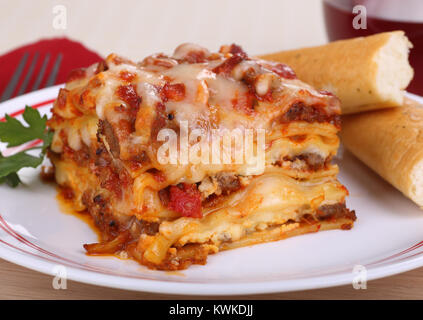 Stück Lasagne mit Raupe klebt auf einer Platte Stockfoto