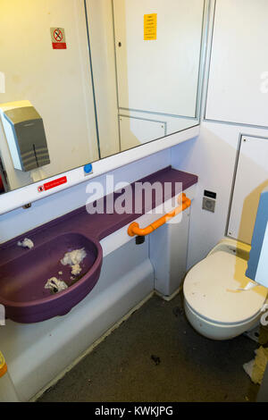 Wc/Toilette und Waschbecken - und dreckig - durch offene Tür (ohne die behinderte Person Zugriff) auf DE Zug in der Nähe von SW London verwendet. UK. (93) Stockfoto