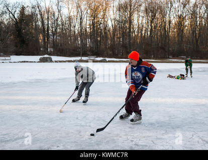 Jungs spielen Eishockey auf einem zugefrorenen Teich Stockfoto