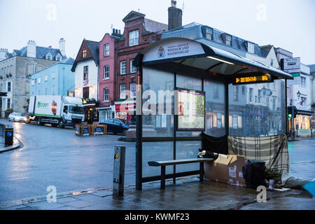 Windsor, Großbritannien. Am 4. Januar, 2018. Eine obdachlose Person schläft unter einer Bushaltestelle vor Windsor Castle. Simon Dudley, der konservative Führer des Royal Borough of Windsor und Maidenhead, hat nach einer Aussage gestern gemacht, die für die polizeiliche Nutzung rechtlicher Befugnisse im Bereich der wohnungslosen Menschen zu löschen, bevor die königliche Hochzeit im Mai wurden kritisiert. Credit: Mark Kerrison/Alamy leben Nachrichten Stockfoto