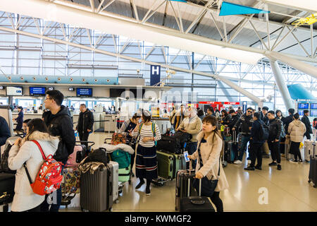 Japan, Kansia Flughafen, Innenraum. Internationaler Abflug Check-in Zone. Warteschlangen von Menschen, vor allem in Asien, noch in am Check-in-Schalter während der langen Zeit nach drei Tag neues Jahr Urlaub. Stockfoto
