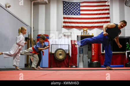 Moline, Iowa, USA. 28 Dez, 2016. Kung-Fu Lehrer John Morrow führt Studenten Zoe Allmon, 5, von LeClaire und Robert Majchrzak, 8, von LeClaire in seinem Studio in Moline am Mittwoch, 28. Dezember 2016. Morgen ist im Guinness Buch der Rekorde für den Abschluss 123 Liegestütze in einer Minute und sieht zu tun 1.000 pushups, 1000 Bein, und 1.000 Sit-ups in einer Stunde am kommenden Freitag auf seinem 65. Geburtstag. Credit: Andy Abeyta/Viererkabel - Zeiten/ZUMA Draht/Alamy leben Nachrichten Stockfoto