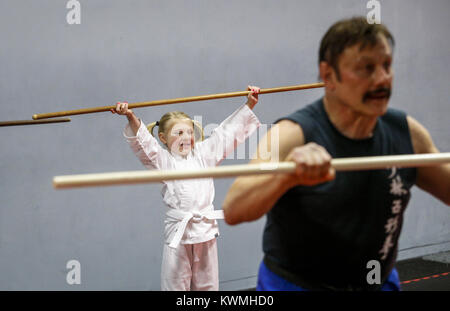 Moline, Iowa, USA. 28 Dez, 2016. Zoe Allmon, 5, von LeClaire erstreckt sich mit Ihrem Personal während der Arbeit aus mit Kung-Fu Lehrer John Morrow in seinem Studio in Moline am Mittwoch, 28. Dezember 2016. Morgen ist im Guinness Buch der Rekorde für den Abschluss 123 Liegestütze in einer Minute und sieht zu tun 1.000 pushups, 1000 Bein, und 1.000 Sit-ups in einer Stunde am kommenden Freitag auf seinem 65. Geburtstag. Credit: Andy Abeyta/Viererkabel - Zeiten/ZUMA Draht/Alamy leben Nachrichten Stockfoto