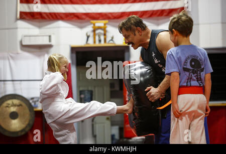 Moline, Iowa, USA. 28 Dez, 2016. Zoe Allmon, 5, von LeClaire hat einen Beutel kick Training mit Kung-Fu Lehrer John MORROW wie Robert Majchrzak, 8, von LeClaire für seine Umdrehung in Moline am Mittwoch wartet, 28. Dezember 2016. Morgen ist im Guinness Buch der Rekorde für den Abschluss 123 Liegestütze in einer Minute und sieht zu tun 1.000 pushups, 1000 Bein, und 1.000 Sit-ups in einer Stunde am kommenden Freitag auf seinem 65. Geburtstag. Credit: Andy Abeyta/Viererkabel - Zeiten/ZUMA Draht/Alamy leben Nachrichten Stockfoto