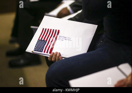 Davenport, Iowa, USA. 8 Dez, 2017. Eine neue Bürger hält seine Dokumente und amerikanische Flagge während einer Einbürgerung Zeremonie an der U.S. District Courthouse in Davenport am Freitag, 8. Dezember 2017. Während die Einbürgerung Zeremonie 43 Personen gewährt wurden, Staatsbürgerschaft aus 23 verschiedenen Ländern kommen. Credit: Andy Abeyta/Viererkabel - Zeiten/ZUMA Draht/Alamy leben Nachrichten Stockfoto